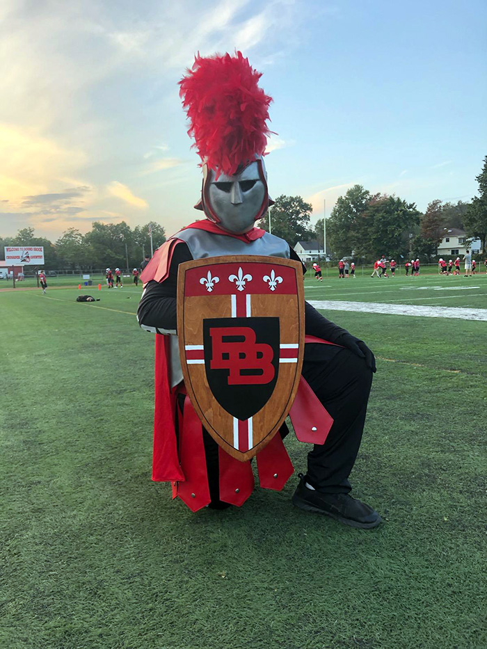 Crusader mascot holds shield on football field