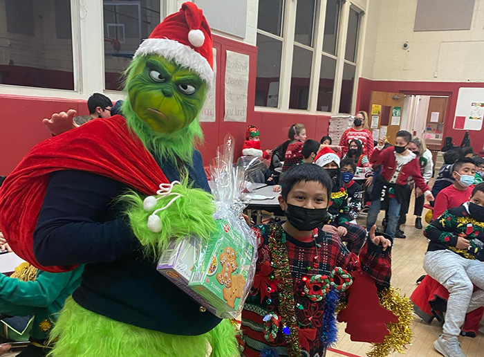 Grinch gives gifts to students at holiday event