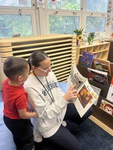 Teacher reads book to student in pre-kindergarten classroom