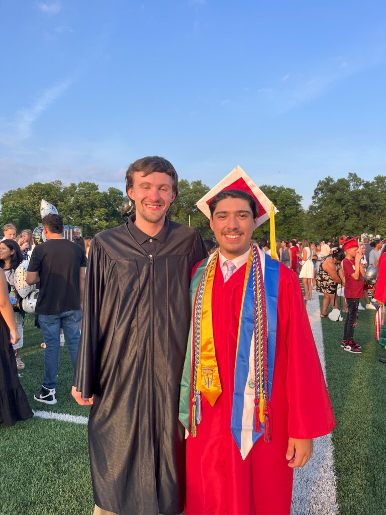 A teacher and student pose for a photo after the graduation.