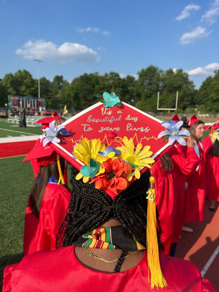 A graduation cap decorated with flowers that reads, "It's a beautiful day to save lives."