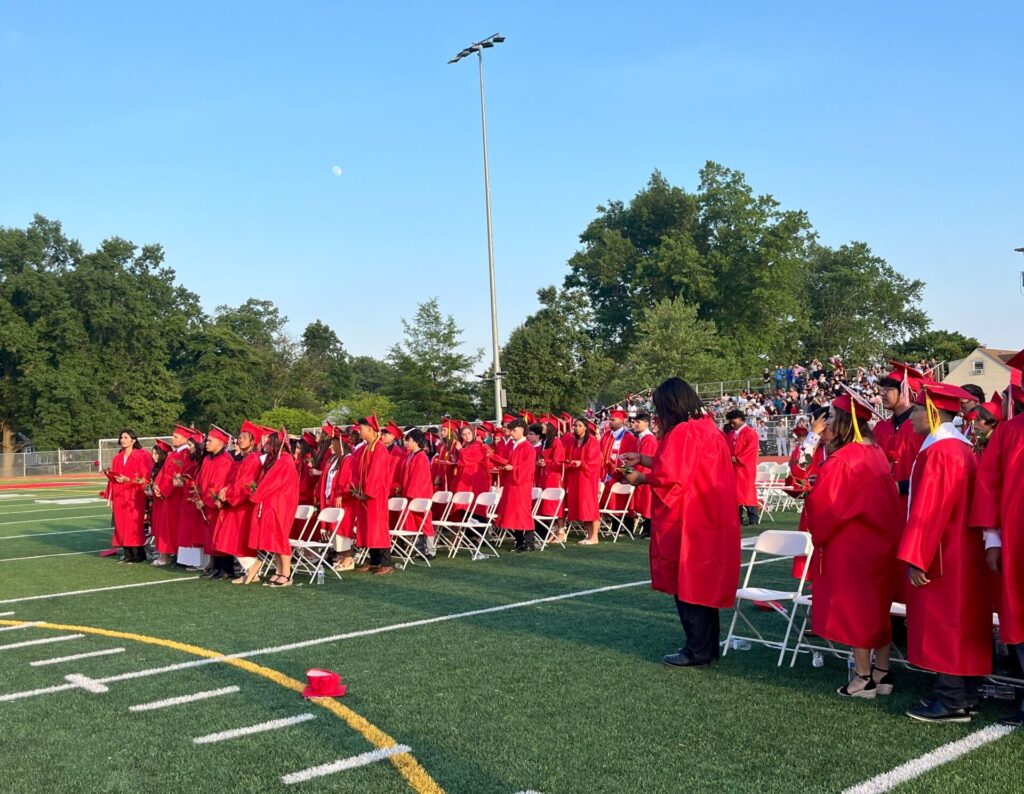 A photo of graduates on the field during the ceremony.